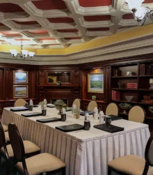 Elegant meeting room with wooden decor and a set dining table for a gathering.