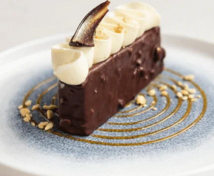 Elegant chocolate dessert elegantly presented on a decorated plate.