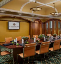 Elegant conference room set for a meeting with warm lighting and green accents.