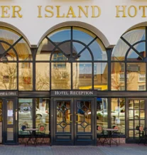 Entrance of River Island Hotel with inviting tables outside Cons Bar & Grill.