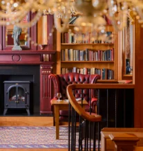 Cosy hotel lounge with fireplace and bookshelf