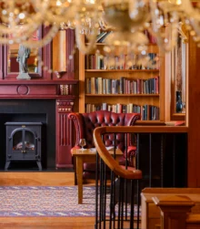 Cosy hotel lounge with fireplace and bookshelf