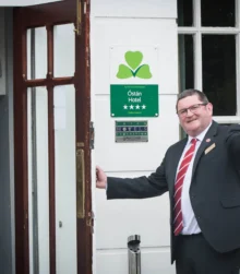 Welcoming hotel staff greets guests at entrance with open arms.