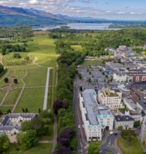 Aerial view of a picturesque town with lush green parks and scenic landscapes.