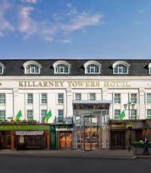Elegant exterior of Killarney Towers Hotel under a blue sky.