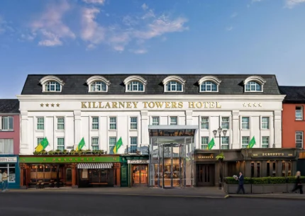 Elegant exterior of Killarney Towers Hotel under a blue sky.