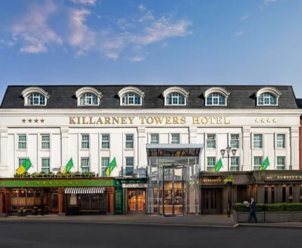 Elegant exterior of Killarney Towers Hotel under a blue sky.