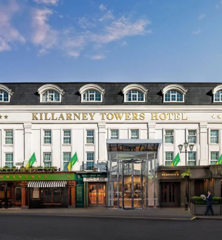 Elegant exterior of Killarney Towers Hotel under a blue sky.