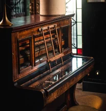 Warm, cosy piano corner in a welcoming hotel lobby.