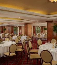 Elegant hotel dining room with round tables set for family gatherings.