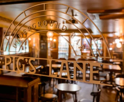 Cosy bar interior at Pig's Lane with inviting warm lighting.