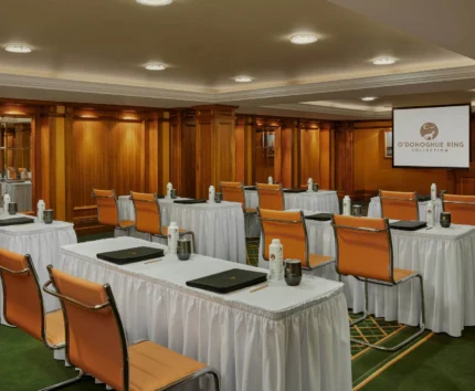 Elegant conference room with leather chairs and presentation screen.