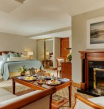 Cosy hotel room with breakfast served for a family on a wooden table.