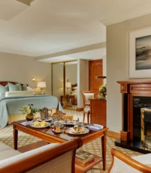Cosy hotel room with breakfast served for a family on a wooden table.