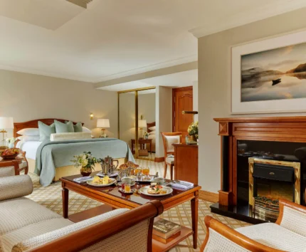 Cosy hotel room with breakfast served for a family on a wooden table.