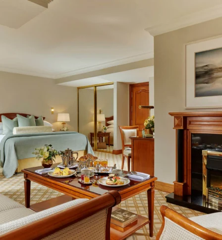 Cosy hotel room with breakfast served for a family on a wooden table.