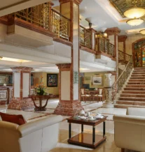 Elegant hotel lobby with plush seating and grand staircase.