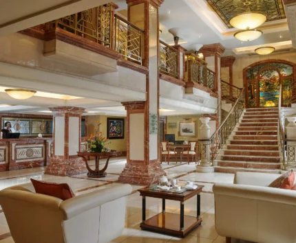 Elegant hotel lobby with plush seating and grand staircase.