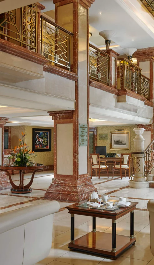 Elegant hotel lobby with plush seating and grand staircase.