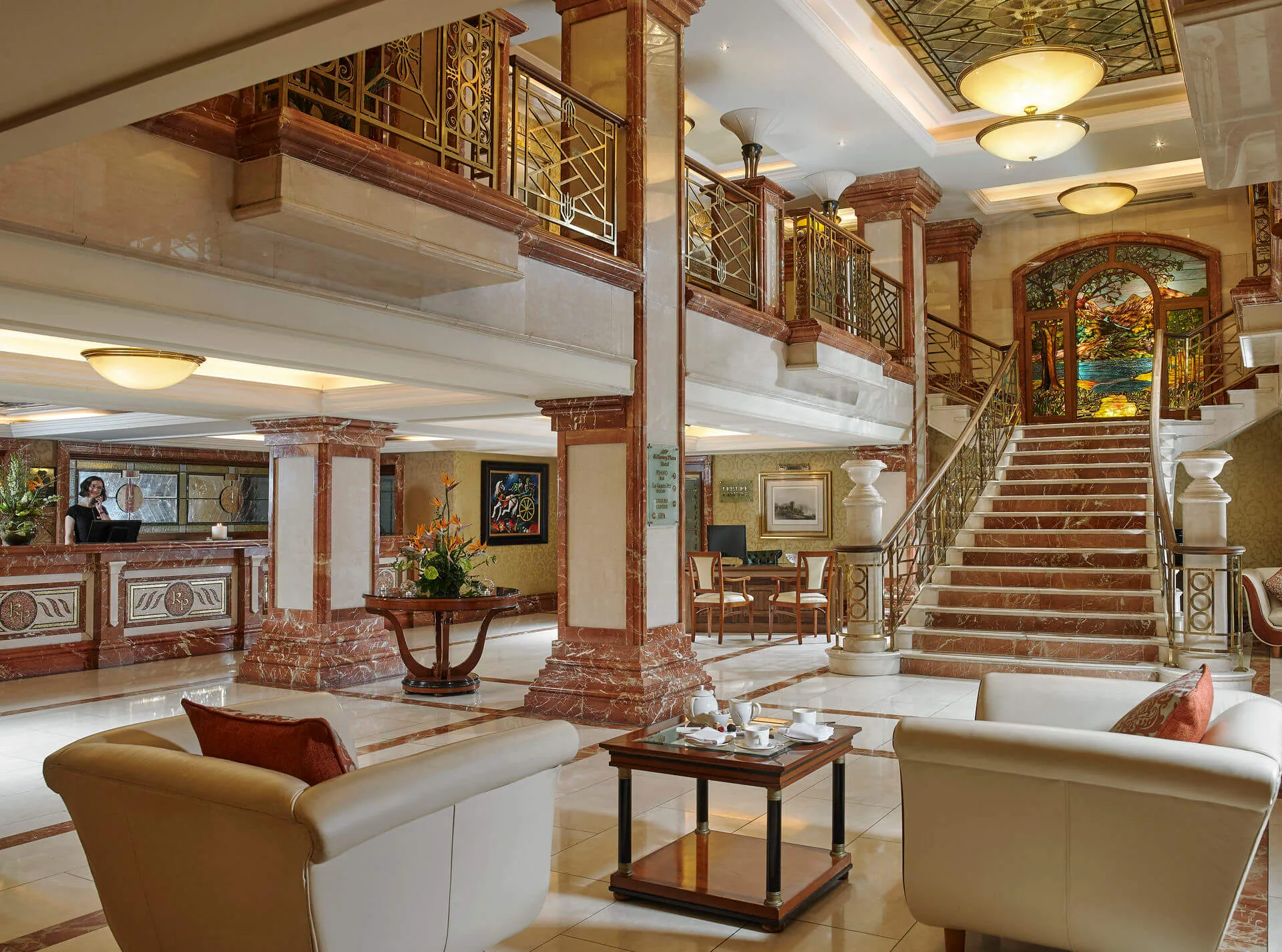 Elegant hotel lobby with plush seating and grand staircase.