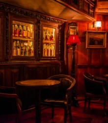 Cosy, dimly lit pub with wooden tables and a warmly glowing bar.