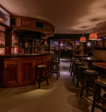 Cozy and inviting pub interior with warm lighting and wooden bar stools.