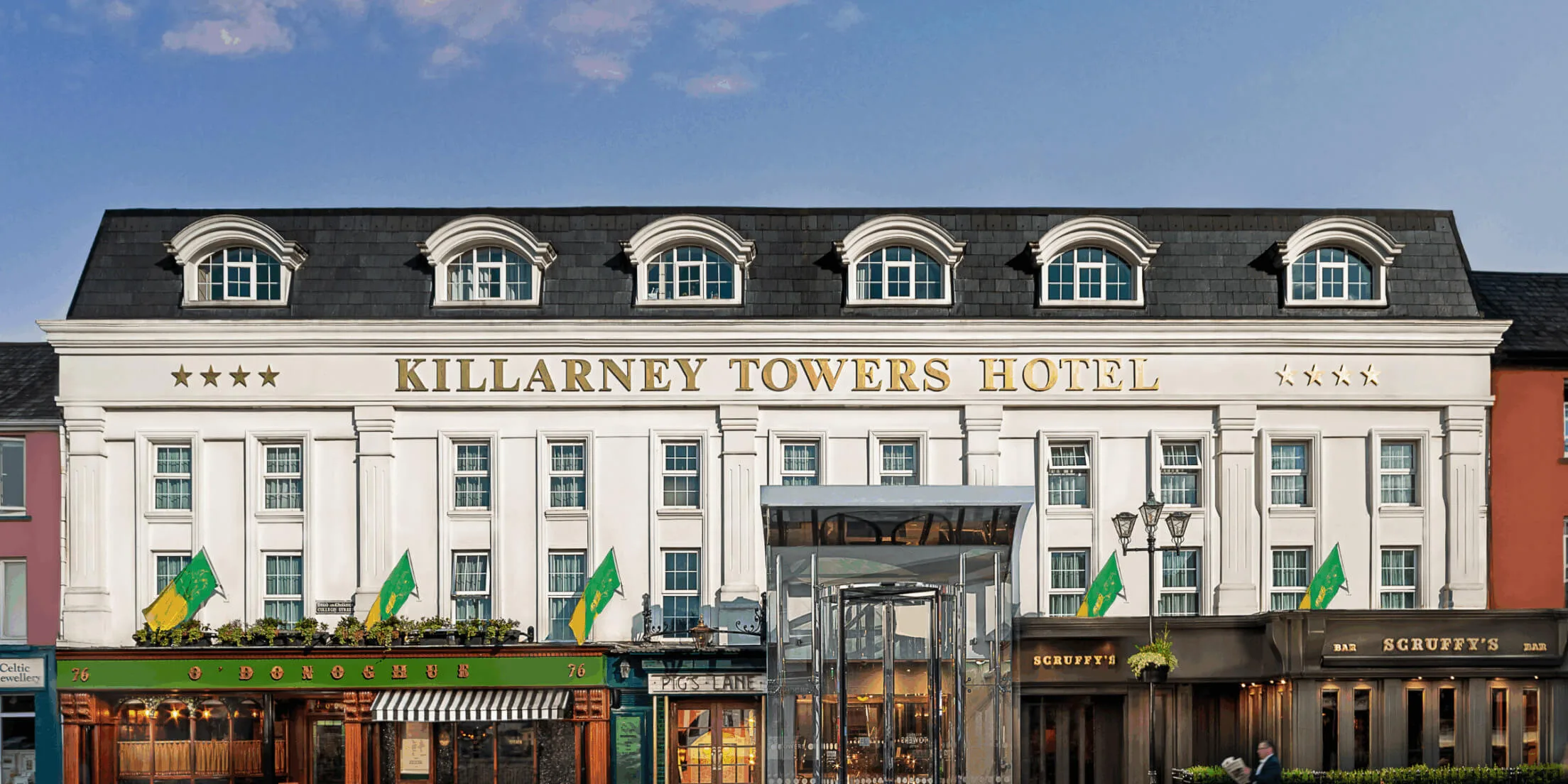 Elegant facade of Killarney Towers Hotel with Irish flags and welcoming atmosphere.