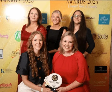 A joyful group posing with an award at a hospitality event, showcasing camaraderie and celebration.