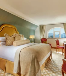 Cosy hotel room with plush bed, elegant decor, and mountain view.