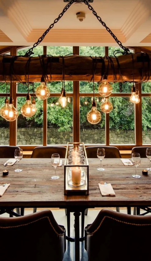 Rustic dining table with warm lighting in cosy hotel setting.