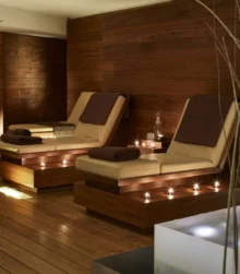 Warm spa relaxation area with two family‑friendly loungers, soft cushions and ambient lights