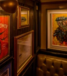 Cosy pub with art-adorned walls and soft, intimate lighting.