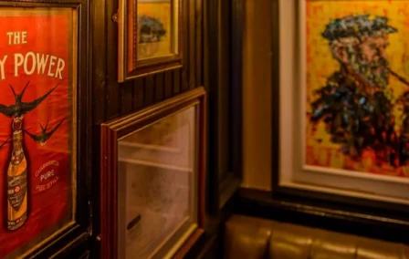 Cosy pub with art-adorned walls and soft, intimate lighting.
