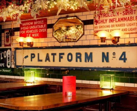 Cosy pub setting with festive decor and ambient lighting around a wooden table.