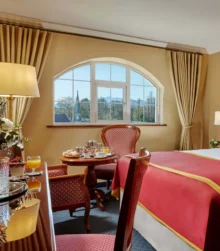 Cosy hotel room with breakfast setup and scenic window view.
