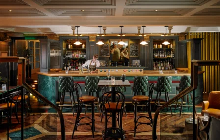 Family enjoying a cosy evening at a stylish, wood-paneled hotel bar.