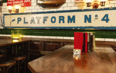 Cosy pub setting with vintage signs and wooden tables.
