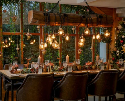 Elegant festive dining room with glowing lights and a decorated Christmas tree.