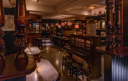 Cosy hotel bar with warm lighting, vintage decor, and intimate seating for groups.
