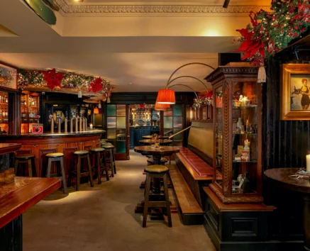 Cosy pub interior with festive decor, warm lighting, and welcoming seating.