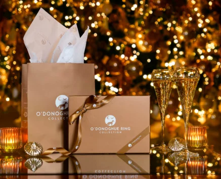 Festive O'Donoghue Ring gifts and sparkling glasses by a glowing Christmas tree.
