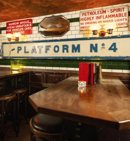Cosy vintage pub setting with warm wood decor and nostalgic railway signage.