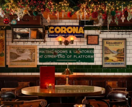 Festive pub interior with vintage posters and holiday decorations.