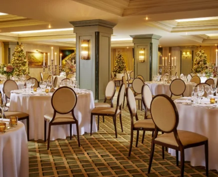 Elegant banquet hall with round tables set for dinner, decorated for a festive celebration.