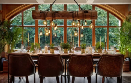 Cosy dining area with rustic decor and lush garden views in a welcoming hotel setting.